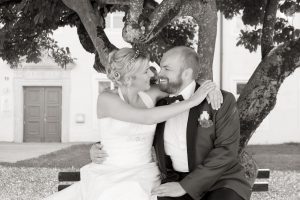 Hochzeitsfotografie Brautpaar auf Bank vor Baum sitzend