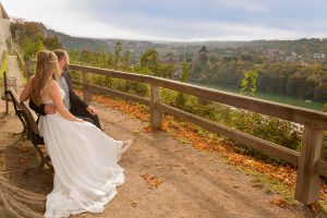 Hochzeitsfotografie Brautpaar auf Bank sitzend mit Ausblick auf See
